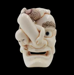Japanese Netsuke Depicting a Child upon an Oni Mask