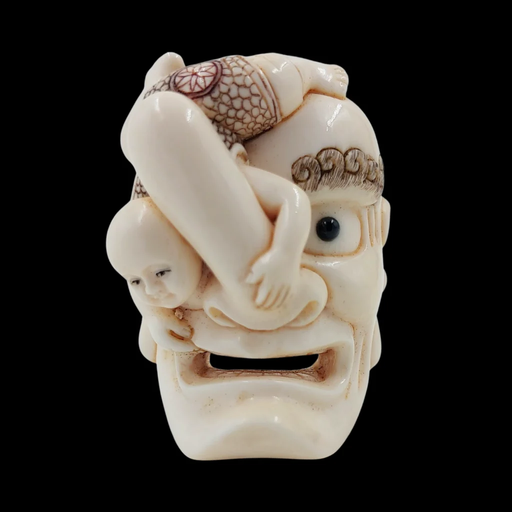 Japanese Netsuke Depicting a Child upon an Oni Mask